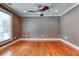 Bedroom features hardwood floors, ceiling fan, neutral paint and natural light from large window at 2680 Bay Ridge Dr, Loganville, GA 30052