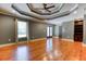 Primary bedroom with tray ceiling, hardwood floors, and a custom built-in bookshelf at 2680 Bay Ridge Dr, Loganville, GA 30052