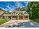 Attached three-car garage with wood doors, stone accents and large driveway on a well maintained lawn at 2680 Bay Ridge Dr, Loganville, GA 30052