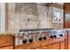 Close-up of stainless steel KitchenAid cooktop with backsplash and stained glass window at 2680 Bay Ridge Dr, Loganville, GA 30052
