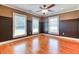 Living room features hardwood floors, neutral paint, ceiling fan, and three windows at 2680 Bay Ridge Dr, Loganville, GA 30052