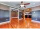 Neutral living room features hardwood flooring, wainscoting, ceiling fan, and view of kitchen at 2680 Bay Ridge Dr, Loganville, GA 30052