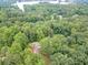 Overhead view showing a house surrounded by lush, mature trees, near a lake and neighborhood at 3329 Walt Stephens Rd, Stockbridge, GA 30281