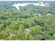 Aerial view of a house nestled in a heavily wooded lot near a lake, showing peaceful privacy at 3329 Walt Stephens Rd, Stockbridge, GA 30281