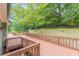An expansive wooden deck with stairs overlooking the green lawn and mature trees at 3329 Walt Stephens Rd, Stockbridge, GA 30281
