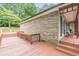 Expansive back deck constructed with wood surrounds the exterior of the brick and siding home at 3329 Walt Stephens Rd, Stockbridge, GA 30281