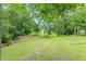 View of the back yard with trees and a well manicured lawn at 3329 Walt Stephens Rd, Stockbridge, GA 30281