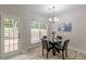 Bright dining area with a glass table, chandelier, and a view to the outdoor deck and backyard at 3329 Walt Stephens Rd, Stockbridge, GA 30281