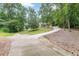 Long concrete driveway leading up to a lovely home surrounded by lush trees and landscaping at 3329 Walt Stephens Rd, Stockbridge, GA 30281