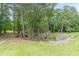 View of a long concrete driveway leading to a private property surrounded by lush woods and large rocks at 3329 Walt Stephens Rd, Stockbridge, GA 30281