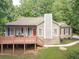Charming home boasts a cozy front porch, brick accents, and a red front door at 3329 Walt Stephens Rd, Stockbridge, GA 30281