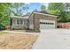A charming brick home featuring a two-car garage, walkway, and professionally landscaped yard at 3329 Walt Stephens Rd, Stockbridge, GA 30281