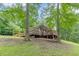 The home features a large wooden deck on a lush green property surrounded by mature shade trees at 3329 Walt Stephens Rd, Stockbridge, GA 30281