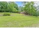 View of the rear side of the home featuring a large wooden deck overlooking the expansive, lush green yard at 3329 Walt Stephens Rd, Stockbridge, GA 30281