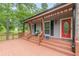 Inviting front porch with a seating area and a red door that adds a pop of color at 3329 Walt Stephens Rd, Stockbridge, GA 30281