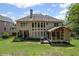 Back exterior view of a home featuring a screened porch, large windows, and a spacious backyard at 4120 Abingdon, Cumming, GA 30041