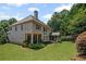 Back exterior view of a two-story home with large windows, screened porch, and well-manicured lawn at 4120 Abingdon, Cumming, GA 30041