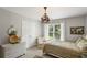Charming bedroom with decorative chandelier, large window overlooking yard, and elegant, neutral decor at 4120 Abingdon, Cumming, GA 30041
