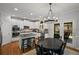 Bright kitchen boasts white cabinetry, stainless appliances, granite countertops, and a view to the outdoor deck at 4120 Abingdon, Cumming, GA 30041