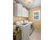 Bright laundry room with white cabinets, washer, dryer, and natural light from the window at 4120 Abingdon, Cumming, GA 30041