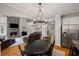 Spacious open-concept living area featuring a stone fireplace, hardwood floors, and modern lighting fixtures at 4120 Abingdon, Cumming, GA 30041