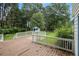 View of a wood back deck with white railings and a view of a treehouse in the back yard at 4214 Fiddlers Bnd, Loganville, GA 30052