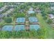 Aerial view featuring a beautiful community with tennis courts and a pool surrounded by lush trees at 4770 Spring Park Cir, Suwanee, GA 30024