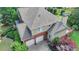 An aerial view showcases a home with manicured landscaping, a two-car garage, and a cozy deck at 4770 Spring Park Cir, Suwanee, GA 30024