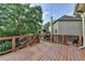 Outdoor deck with wooden floor and rail overlooks a green lawn in the backyard at 4770 Spring Park Cir, Suwanee, GA 30024