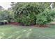 Well-maintained backyard with mature trees, manicured lawn, and metal fence at 4770 Spring Park Cir, Suwanee, GA 30024