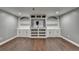 Finished basement area with sleek hardwood floors and custom built-in shelving and cabinetry at 4770 Spring Park Cir, Suwanee, GA 30024