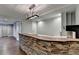 Basement bar area featuring stone accents, modern lighting, and ample countertop space at 4770 Spring Park Cir, Suwanee, GA 30024