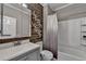 Stylish bathroom with decorative wood paneling, modern fixtures, and a shower-tub combo at 4770 Spring Park Cir, Suwanee, GA 30024