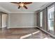 Bedroom featuring hardwood floors, neutral walls, and large window with light-filtering curtains at 4770 Spring Park Cir, Suwanee, GA 30024