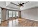 Primary bedroom with tray ceiling, fan, sliding barn door, and hardwood floors at 4770 Spring Park Cir, Suwanee, GA 30024