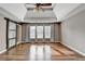 Primary bedroom with tray ceiling, fan, sliding barn door, and hardwood floors at 4770 Spring Park Cir, Suwanee, GA 30024