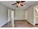 Well-lit bedroom with hardwood floors and neutral walls featuring a ceiling fan and two entry doors at 4770 Spring Park Cir, Suwanee, GA 30024