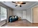 Comfortable bedroom featuring hardwood floors, neutral walls, and a cozy seating area by the window at 4770 Spring Park Cir, Suwanee, GA 30024