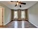 Bright bedroom featuring hardwood floors, neutral walls, ceiling fan, and large windows with modern curtains at 4770 Spring Park Cir, Suwanee, GA 30024