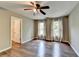 Neutral colored bedroom with hardwood floors, base molding, ceiling fan, and natural light from two windows at 4770 Spring Park Cir, Suwanee, GA 30024