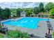 Large community pool with lounge chairs, tables, and well-maintained landscaping at 4770 Spring Park Cir, Suwanee, GA 30024