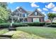 Beautiful two-story brick home with a manicured lawn and a welcoming front porch with beautiful bushes at 4770 Spring Park Cir, Suwanee, GA 30024
