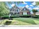 Beautiful two-story brick home with a manicured lawn and a welcoming front porch with beautiful bushes at 4770 Spring Park Cir, Suwanee, GA 30024
