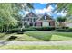 Beautiful two-story brick home with a manicured lawn and a welcoming front porch with beautiful bushes at 4770 Spring Park Cir, Suwanee, GA 30024