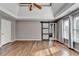 Spacious main bedroom featuring a sliding barn door, tray ceiling, ceiling fan, and two windows with bright natural light at 4770 Spring Park Cir, Suwanee, GA 30024