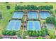 Aerial view of multiple tennis courts surrounded by trees and landscaping at 4770 Spring Park Cir, Suwanee, GA 30024