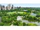 Lush greenery and a lake surround a park and pool with a city view in the background at 1055 Piedmont Ne Ave # 106, Atlanta, GA 30309