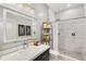 Bathroom featuring marble-tiled shower, dark cabinets, bright vanity mirror, and white counter tops at 1055 Piedmont Ne Ave # 106, Atlanta, GA 30309