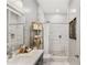 Bathroom featuring marble-tiled shower, dark cabinets, bright vanity mirror, and white counter tops at 1055 Piedmont Ne Ave # 106, Atlanta, GA 30309