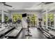 Bright gym with treadmills, elliptical, bike, and mirrored walls overlooking greenery at 1055 Piedmont Ne Ave # 106, Atlanta, GA 30309